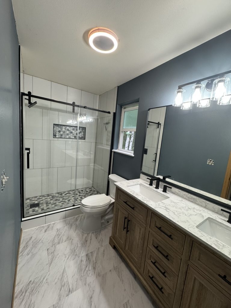 Remodeled bathroom with tiled walk-in shower and double vanity